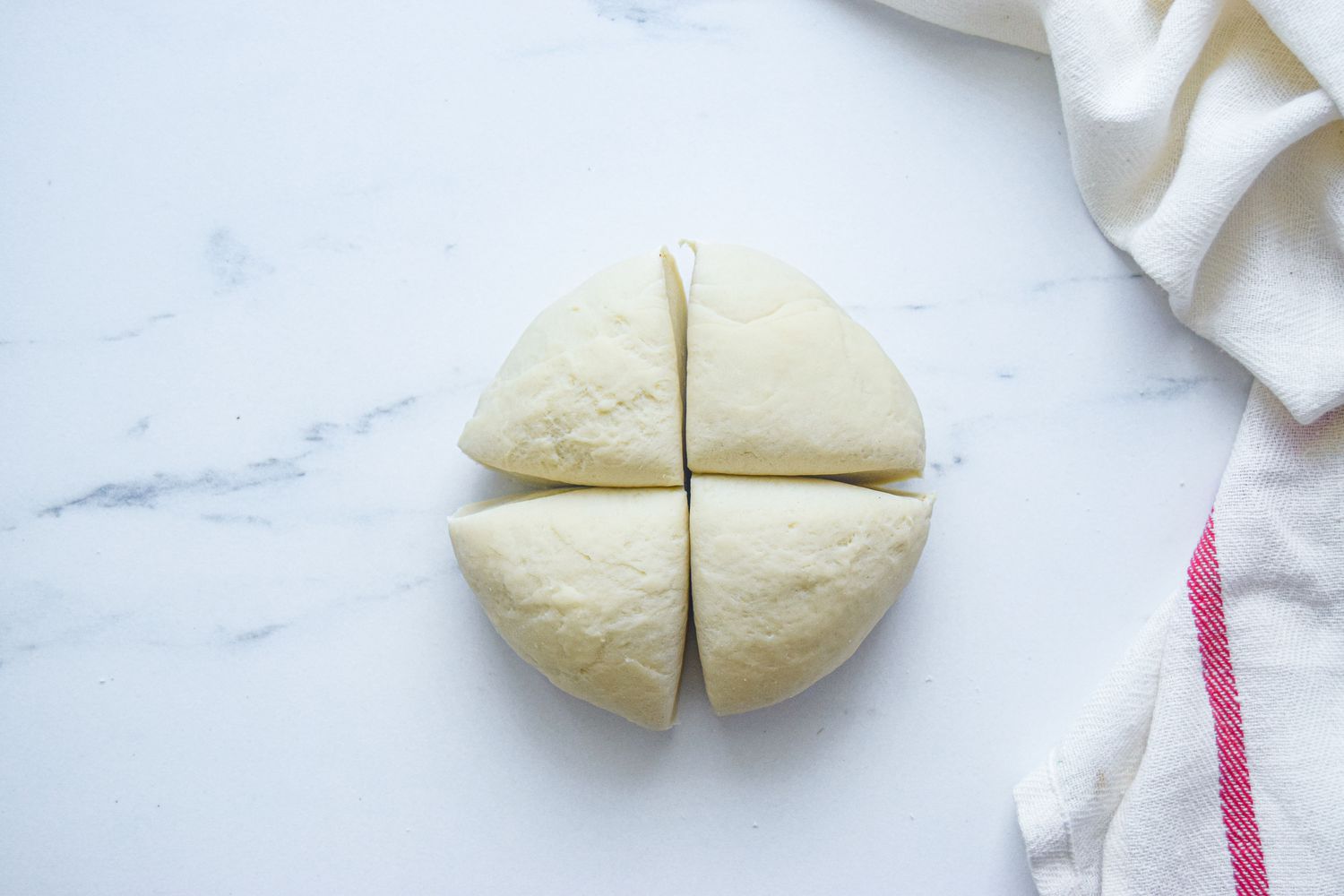 Dough cut into fourths to make scallion pancakes.