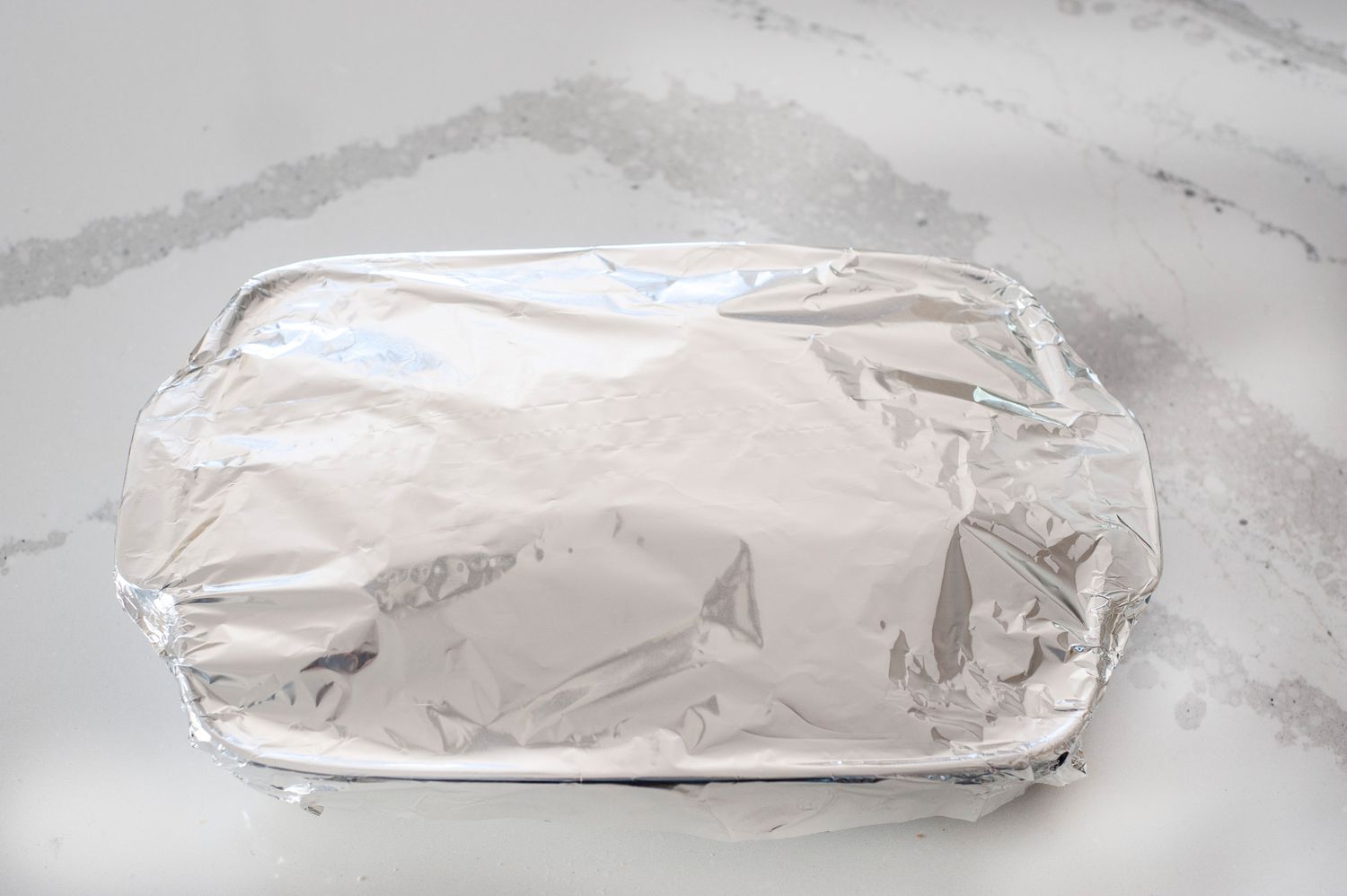Foil covered baking dish of stuffing.
