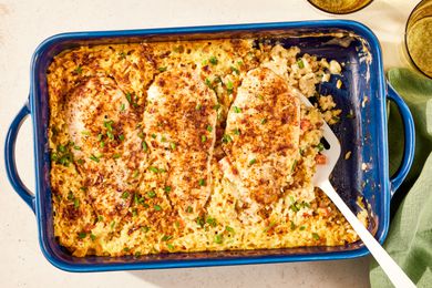 no-peek chicken in a casserole dish at a table setting with two glasses and a table napkin