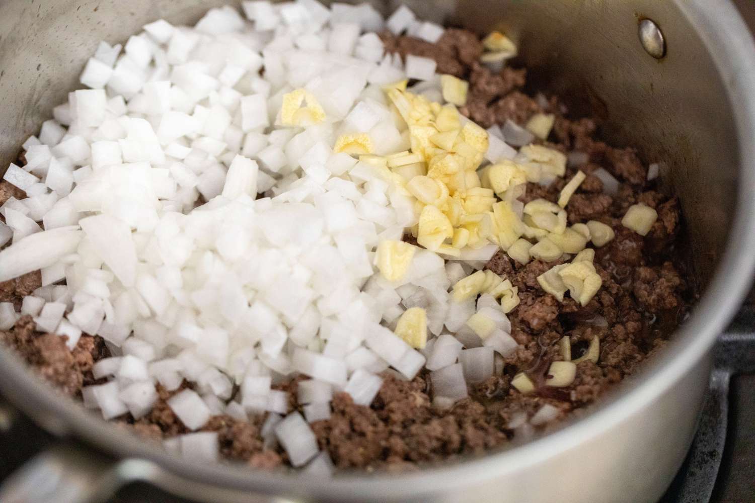 Diced Onions and Garlic Added to Pot of Cooked Ground Beef for NYC Chopped Cheese Recipe