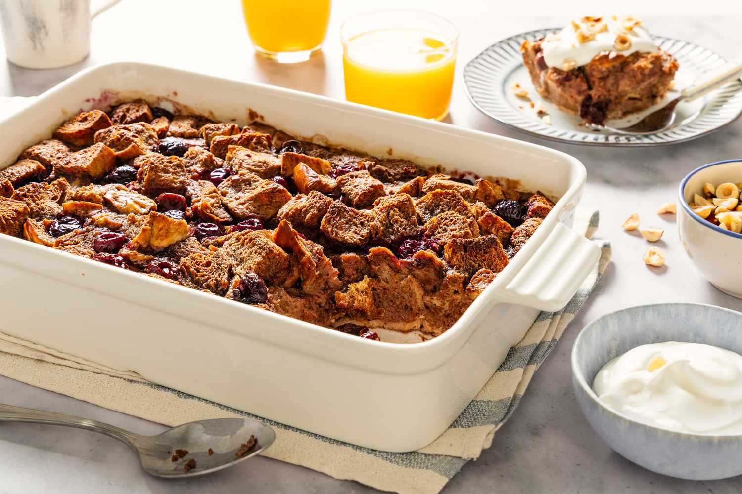 A dish of baked Nutella and cherry French toast with surrounding breakfast items