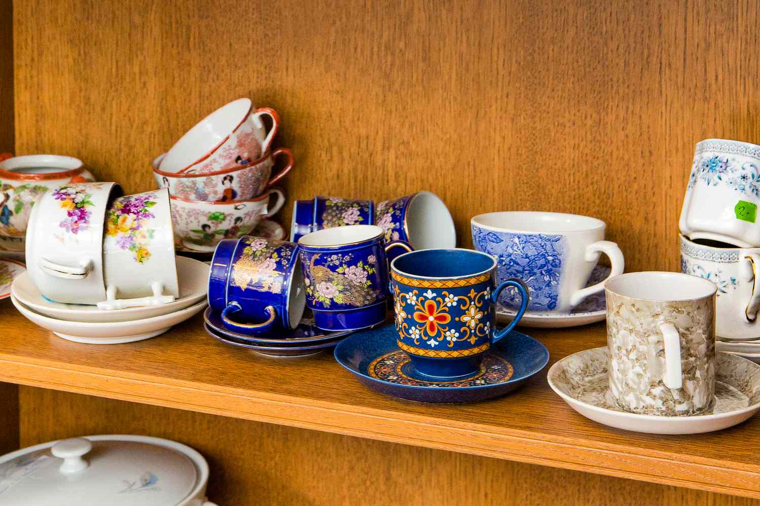 Different used vintage porcelain tea cups and saucers in flea market second hand shop