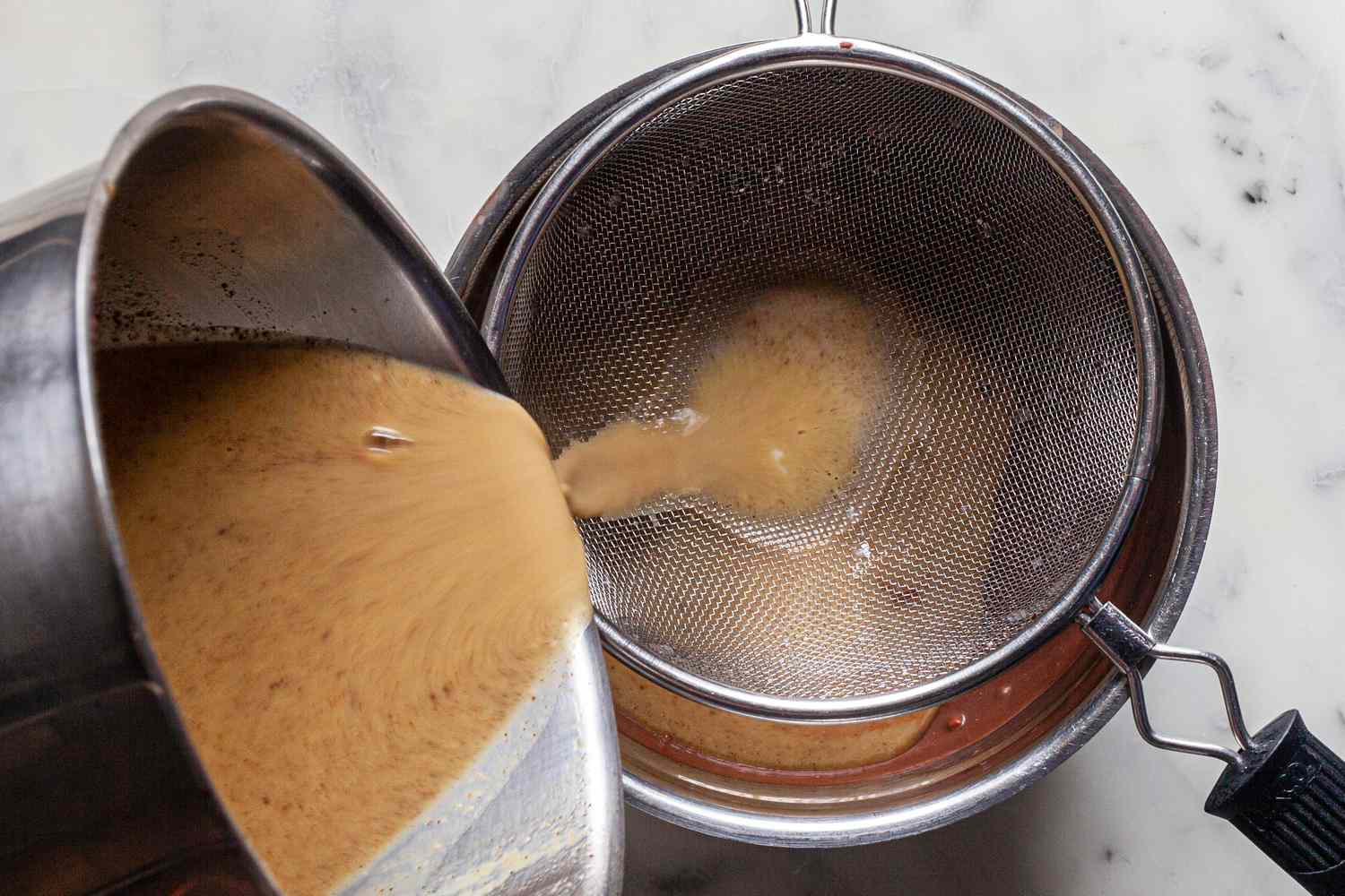 Pouring custard for mexican chocolate through a sieve.