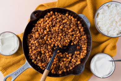 overhead view of 20-Minute One-Pan Beef and Chickpeas in a skillet with a side of greek yogurt and rice