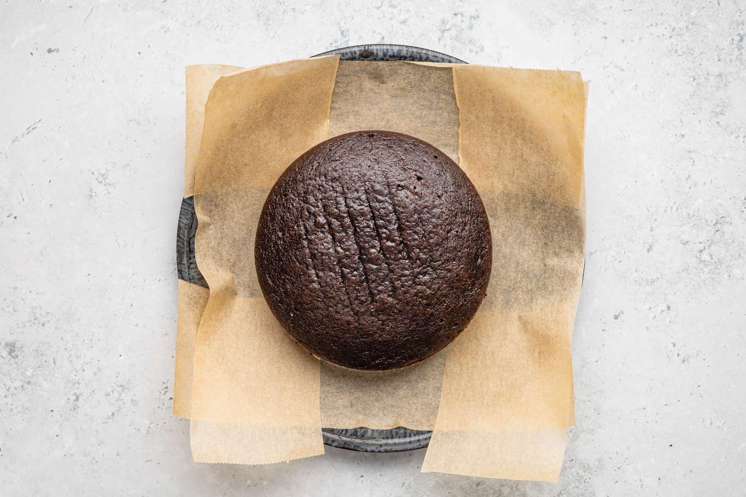 One Layer of Cake Placed on Parchment Paper for One-Bowl Double-Layer Chocolate Cake Recipe