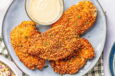pretzel chicken on a plate with a bowl of sweet dijon mayo 