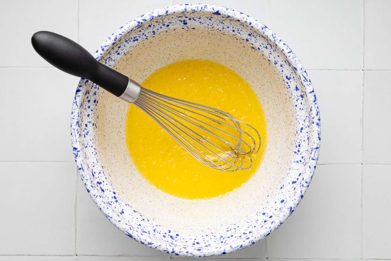 Sugar, Butter, and Oil Whisked Together in a Bowl for Chocolate Chip Banana Muffins Recipe