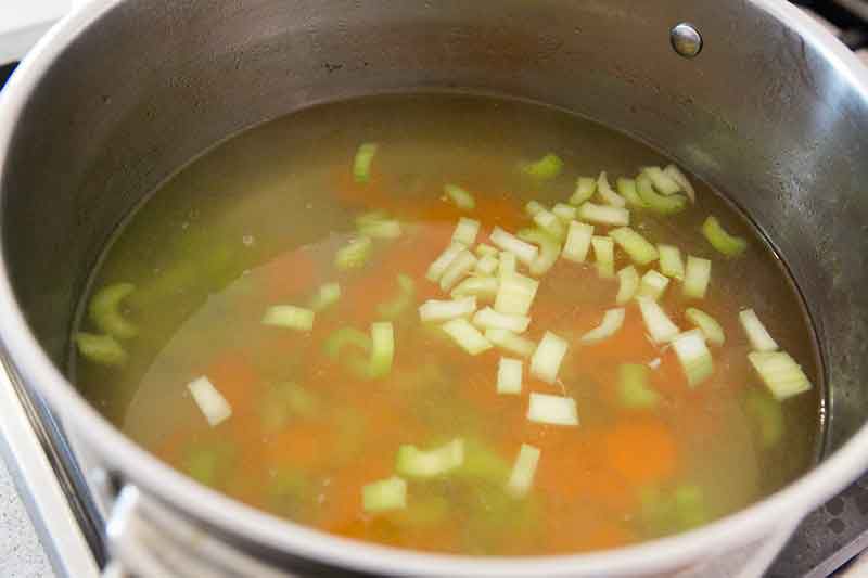 A stockpot of broth for chicken soup.