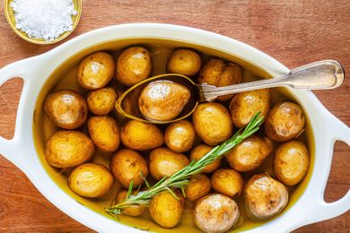 Potato confit in white casserole dish.