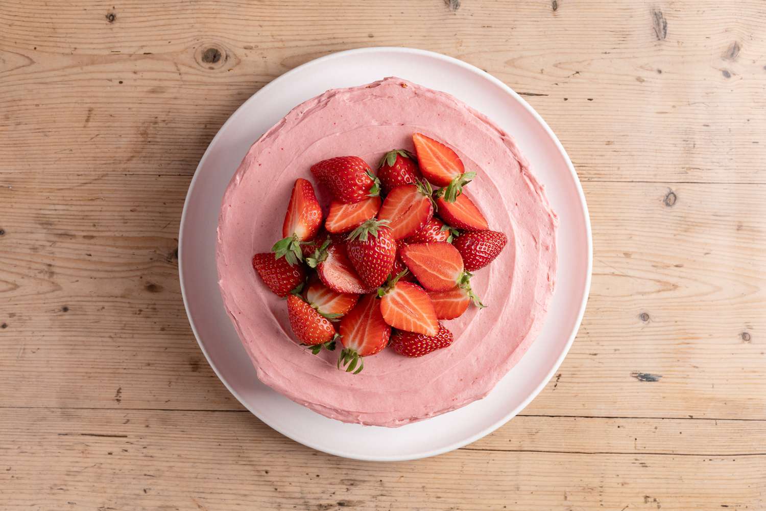 halved strawberries added to strawberry cake
