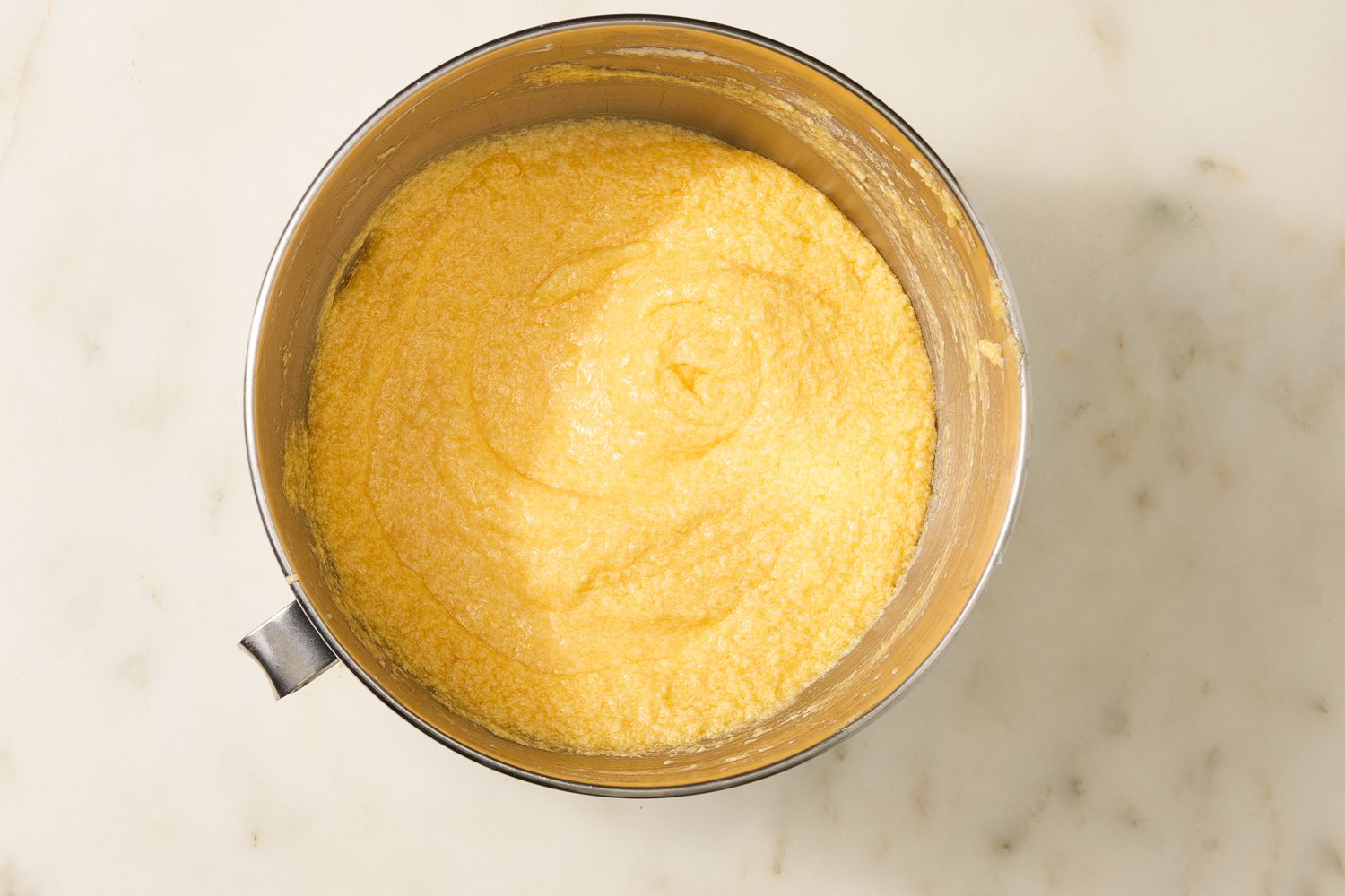 Overhead view of a metal mixer bowl of creamed butter and sugar for Million Dollar Pound Cake recipe