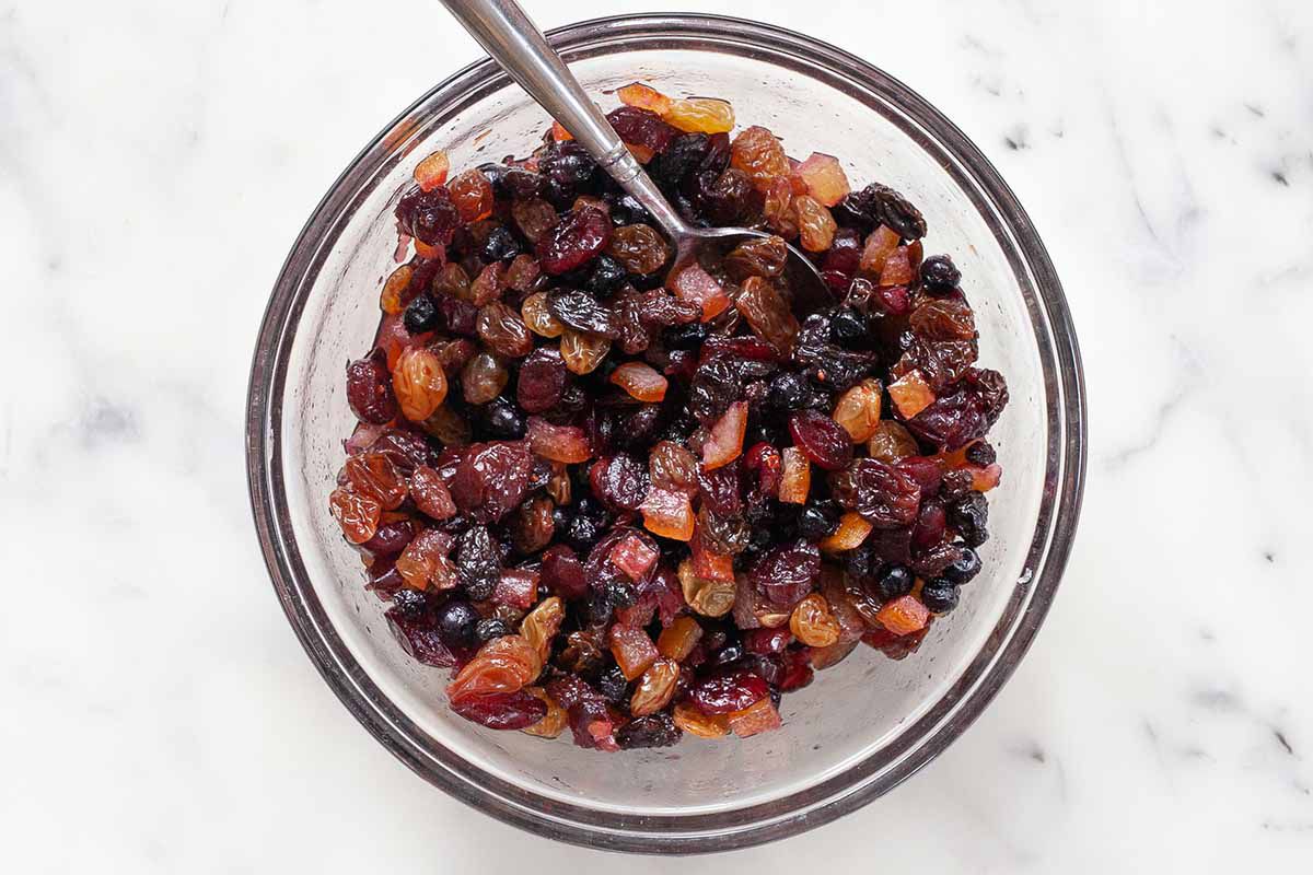 Mixed dried, rum-soaked fruit for German Stollen Christmas bread in a glass bowl.
