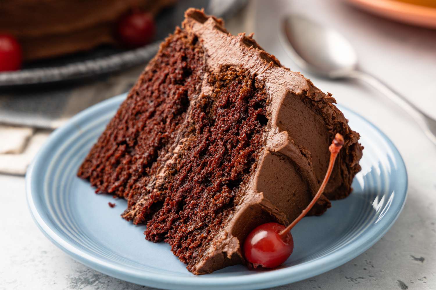 Slice of One-Bowl Double-Layer Chocolate Cake on a Small Plate with a Maraschino Cherry