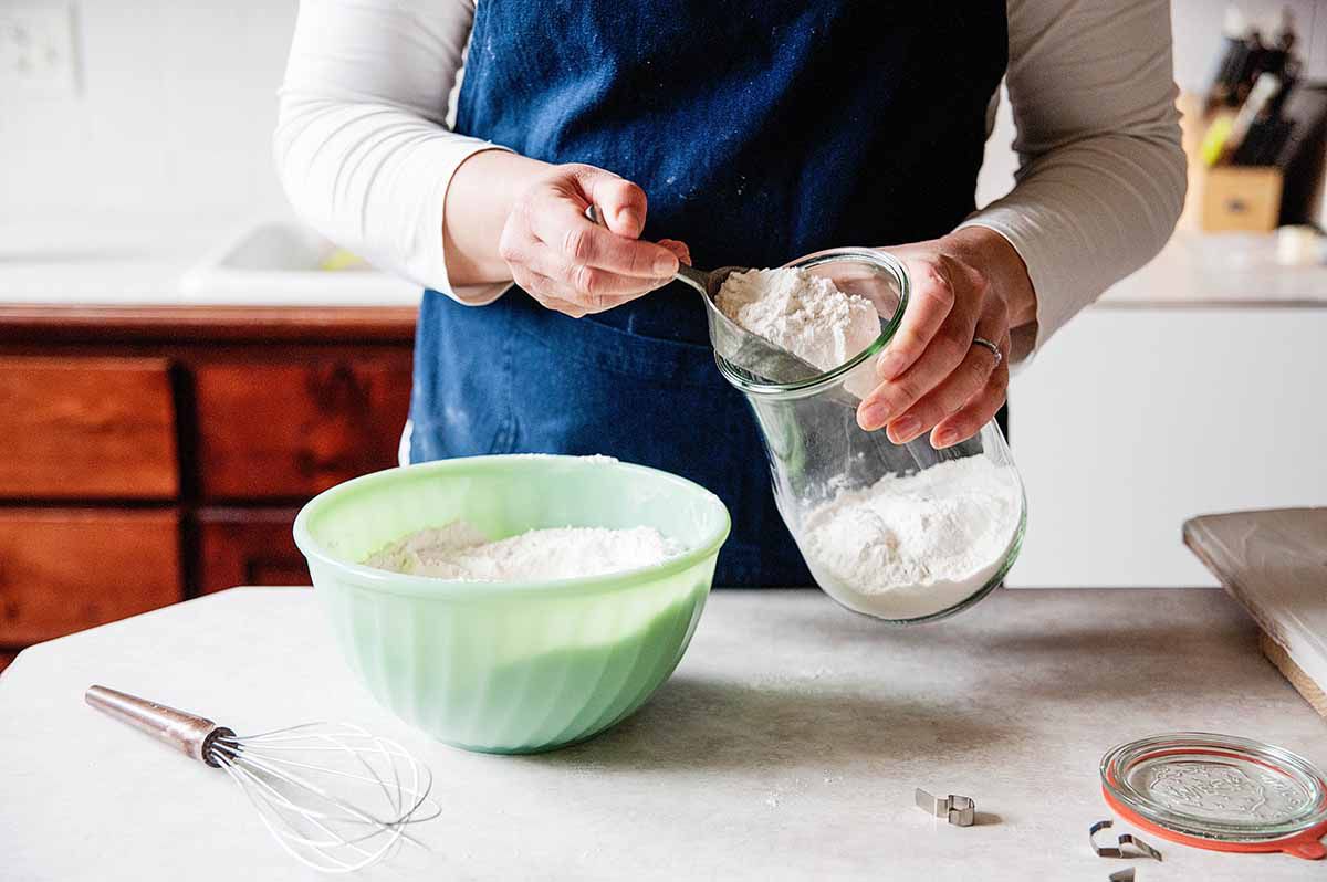 Scooping pancake mix from a jar into a bowl