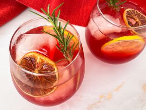 Trader Joe's holiday punch in two glasses garnised with citrus and rosemary