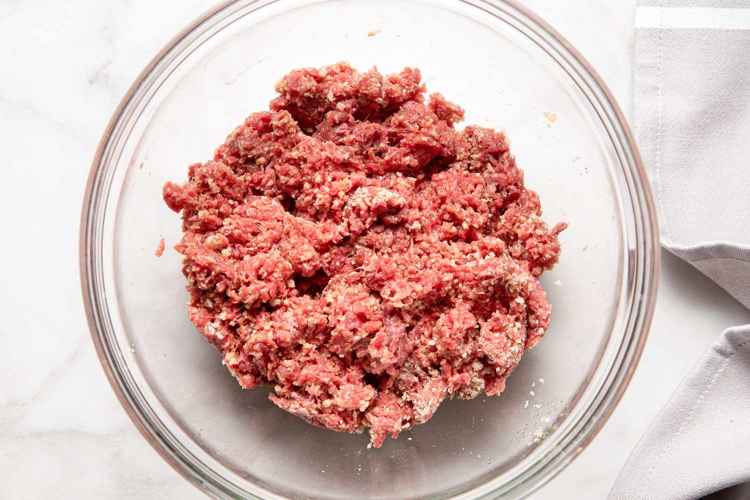 Bowl of Ground Beef on the Counter Next to a White Kitchen Towel for French Onion Meatballs Recipe