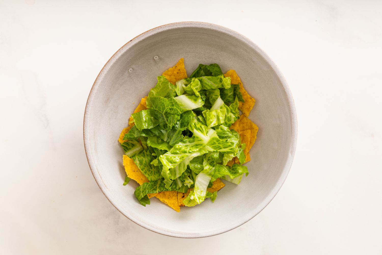 Tostada Topped With Sliced Romaine in a Bowl