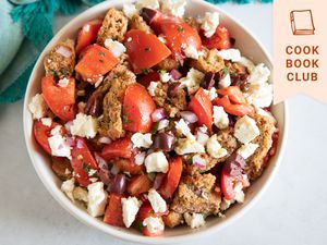 Overhead view of a white bowl filled with Cretan Dakos salad.