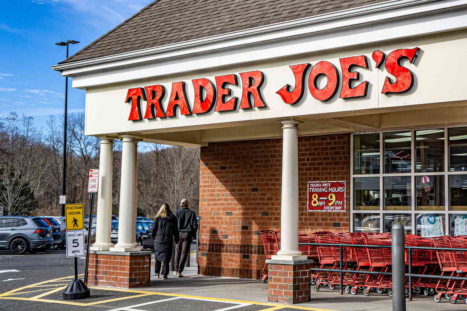 Trader Joe's storefront with shopping carts and pedestrians near the entrance