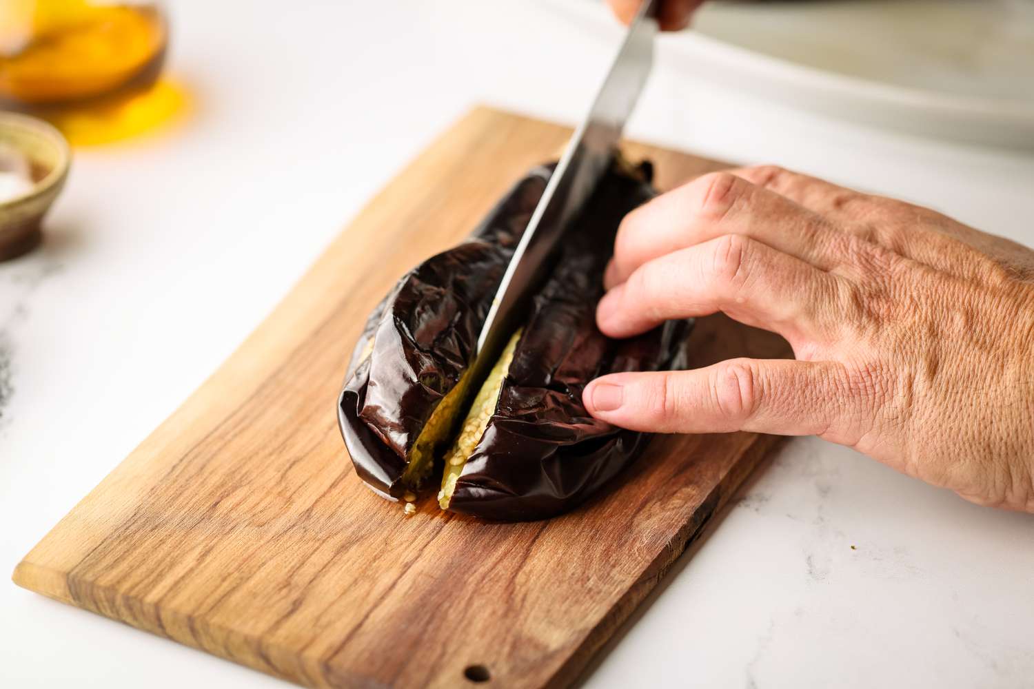 Grilled Eggplant Sliced in Half on a Cutting Board 