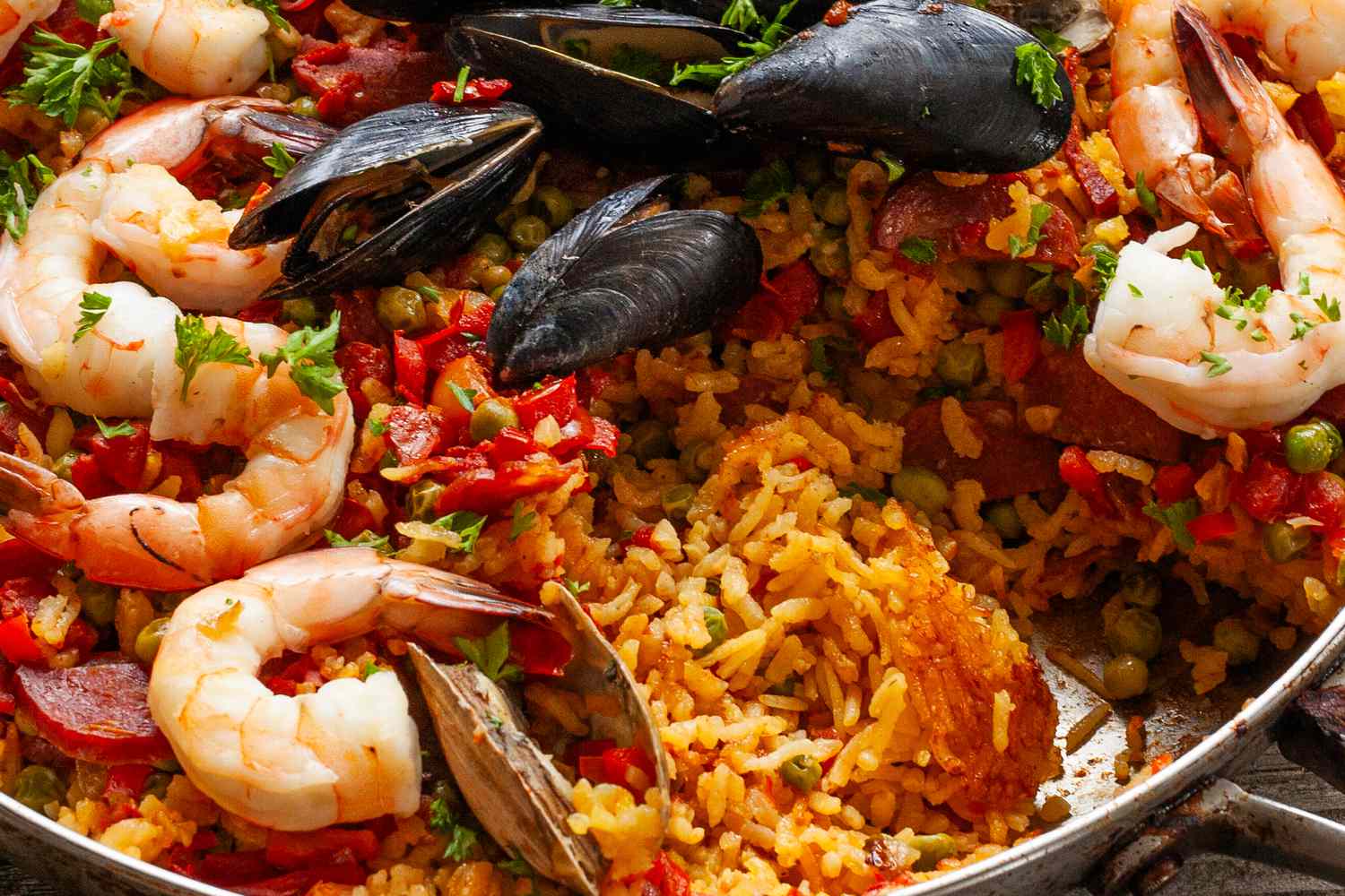 Seafood paella with rice, shrimp, mussels, and vegetables in a pan