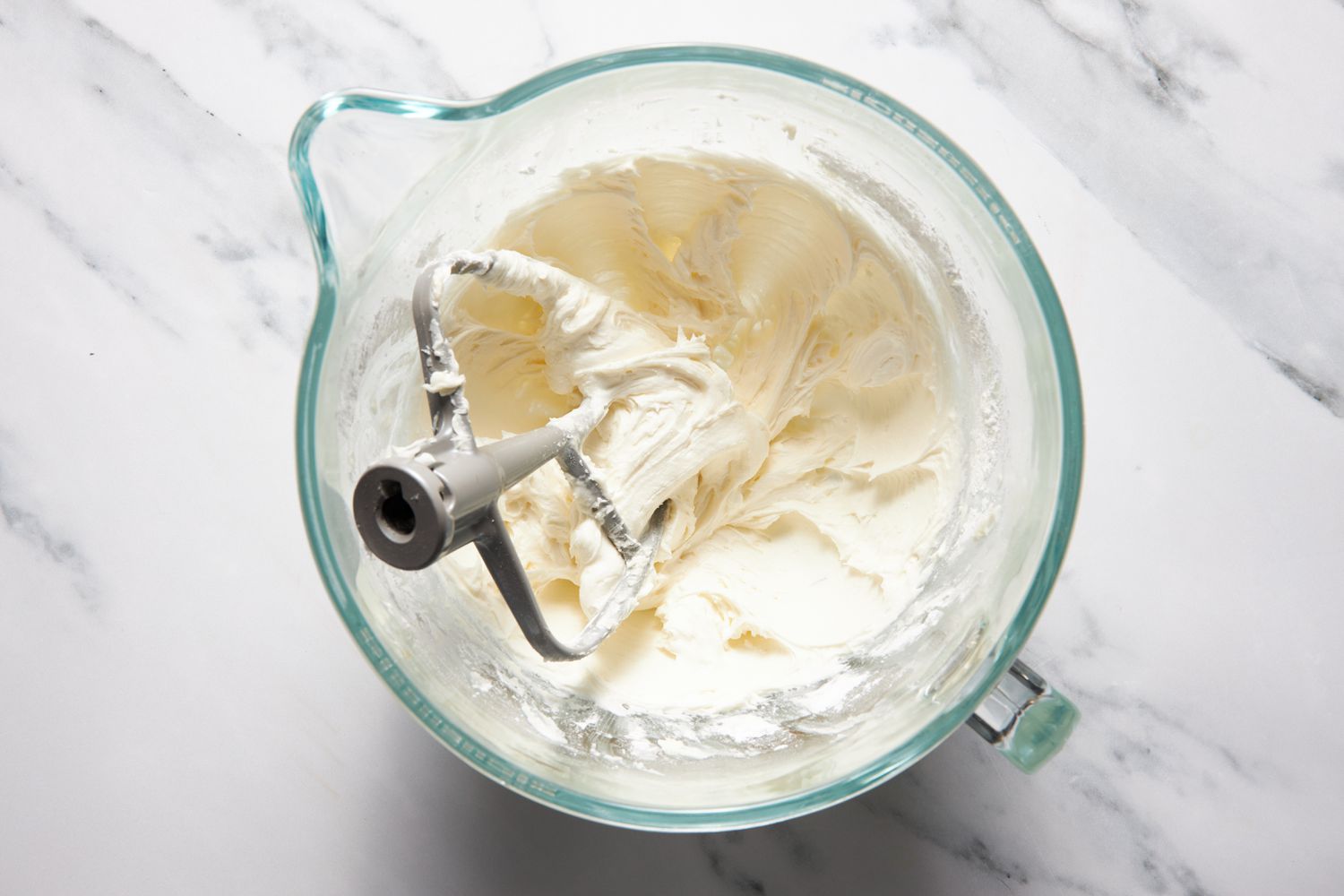 Frosting in a stand mixer bowl for Michigan bumpy cake recipe