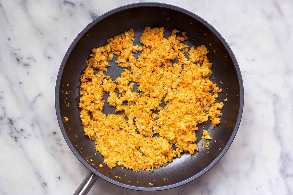 Soffritto being cooked in a dark skillet as the foundation for the perfect pasta bolognese sauce.