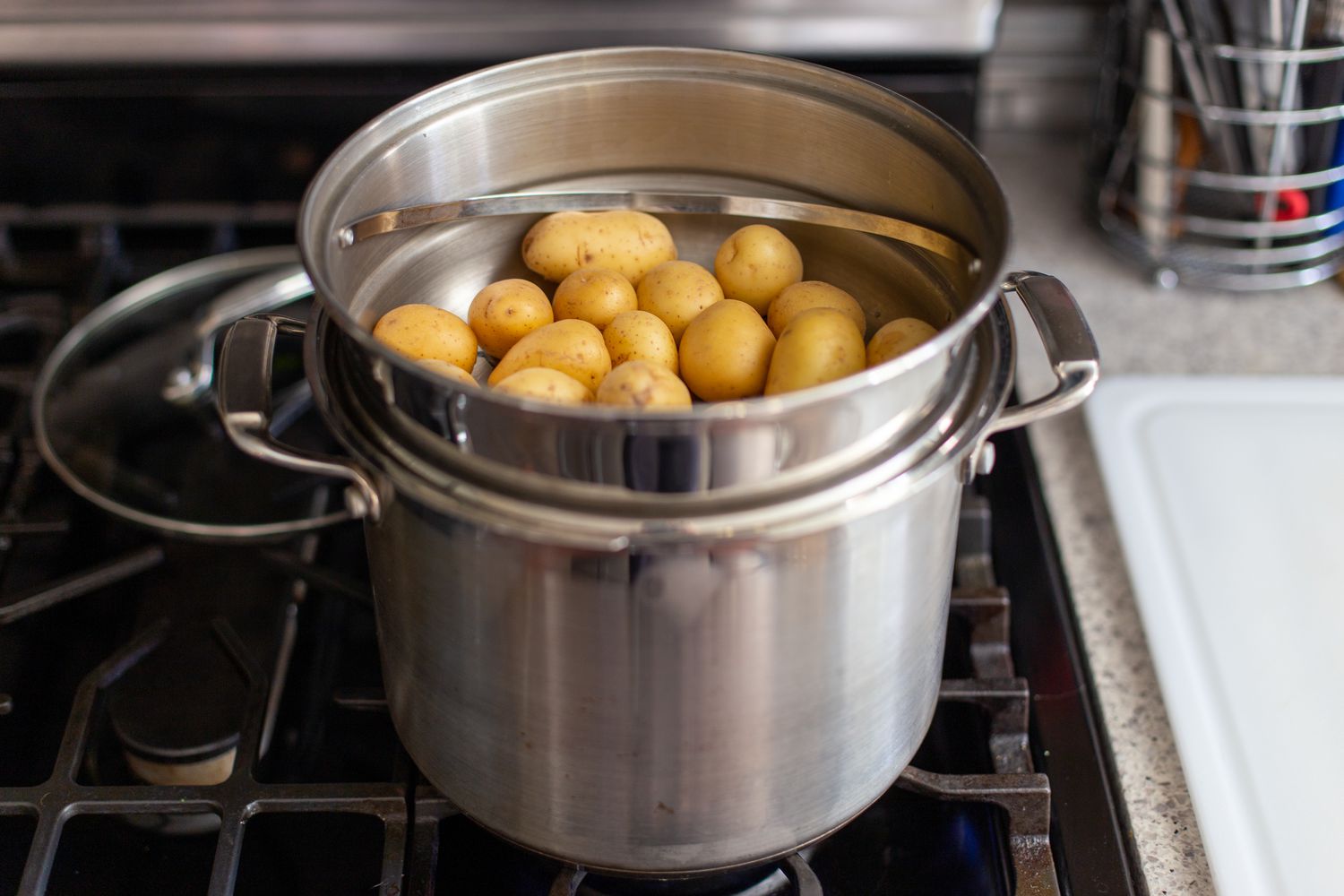 Boiling potatoes to make crispy potatoes with smoked salmon, red onions, and capers