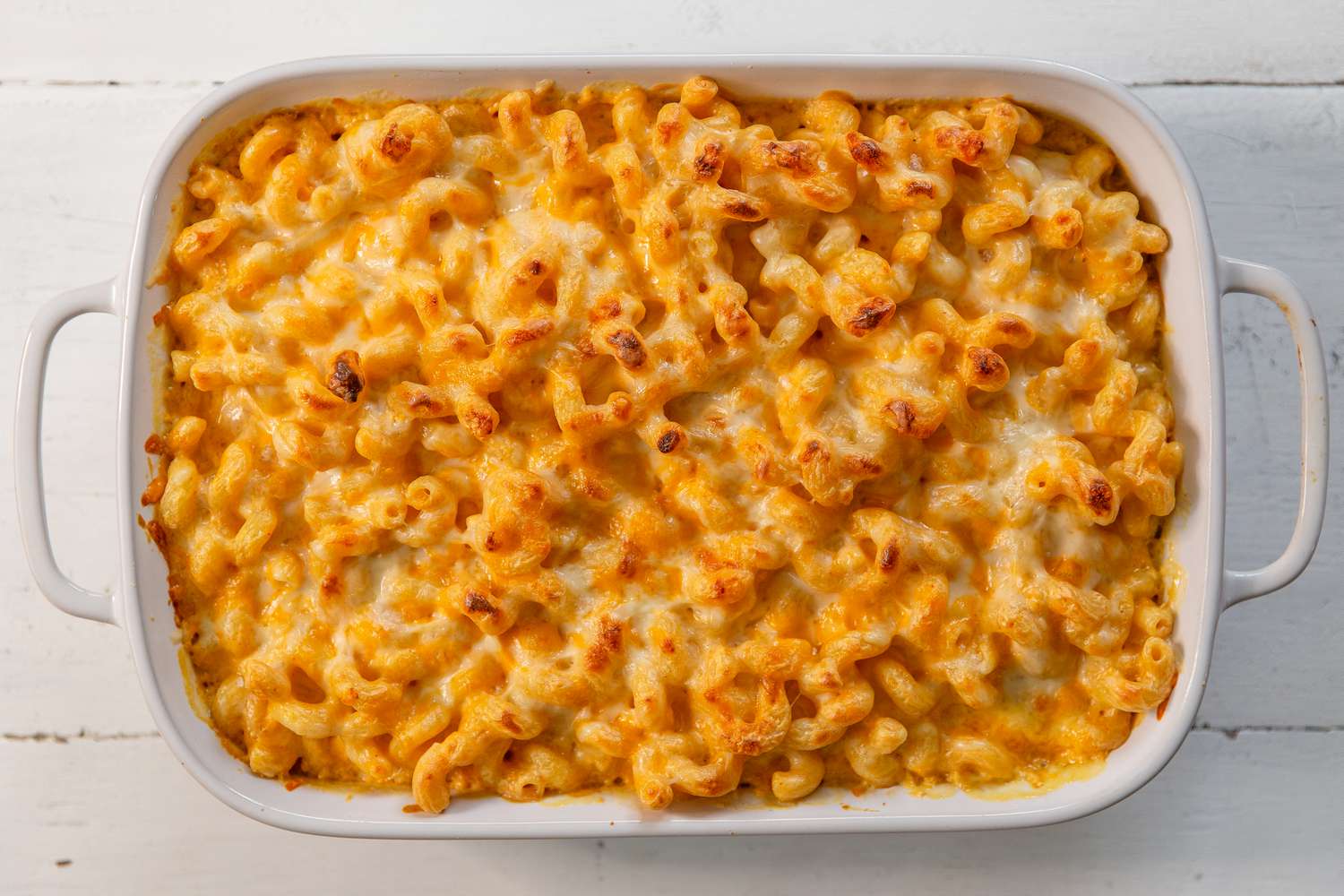 Overhead view of a white baking dish of finished Baked Mac and Cheese recipe 
