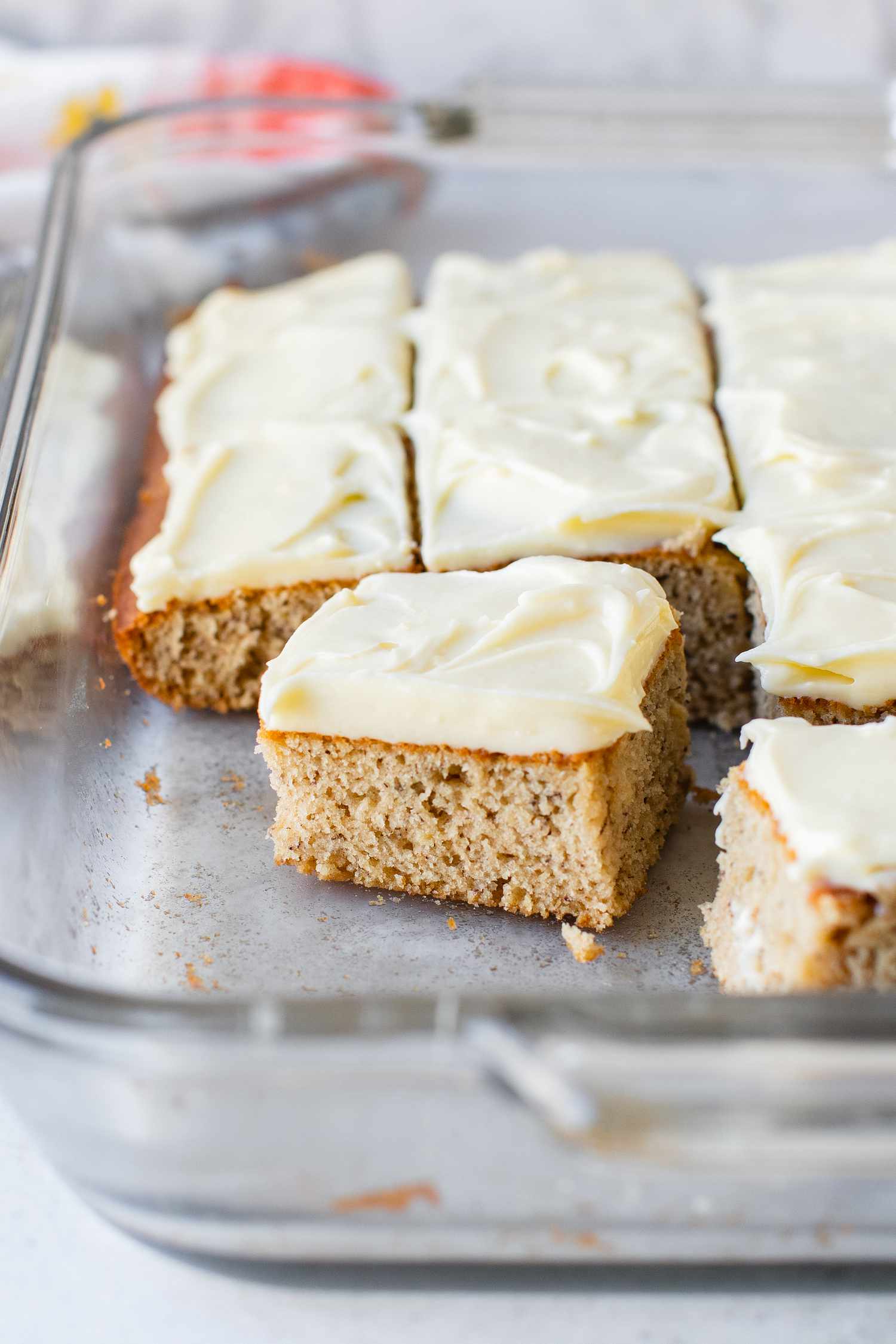 Banana Sheet Cake Cut into Individual Pieces in a Pyrex Dish