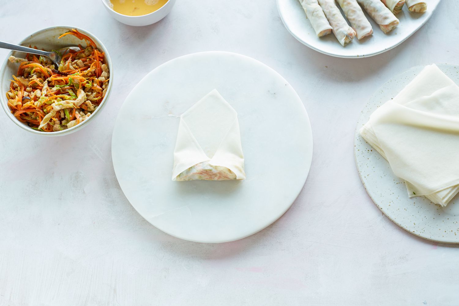 Rolling filling in wrapper to make fried spring rolls.