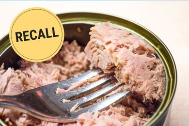 Tuna fish in a can with a fork with the word recall stamped over top