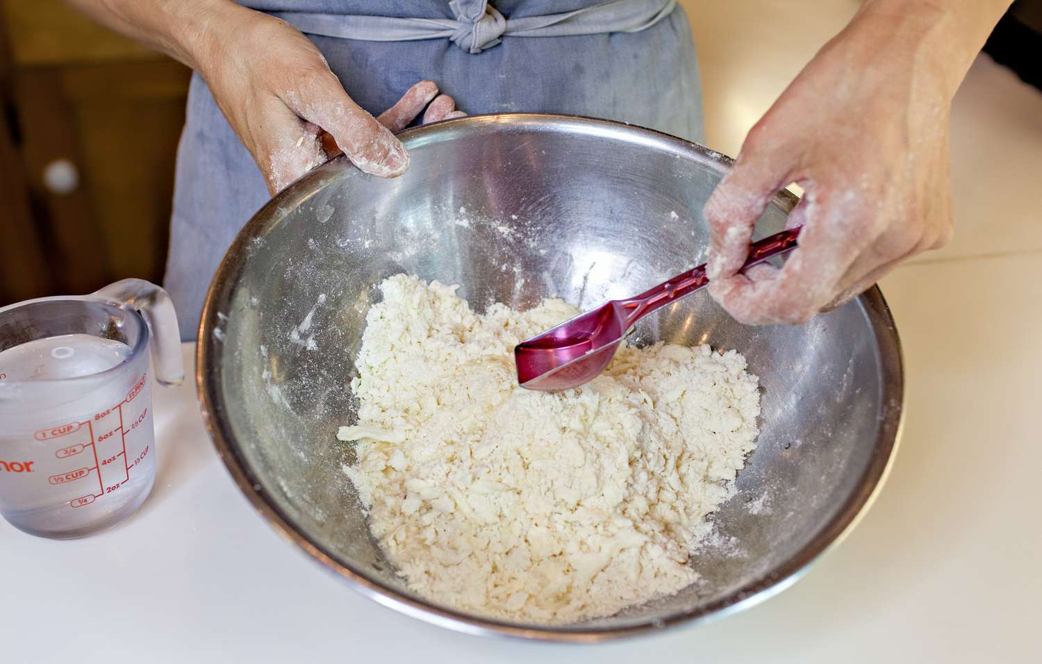 Tablespoon of Ice Water Spooned onto Pie Dough for Manually Made Pie Dough Recipe