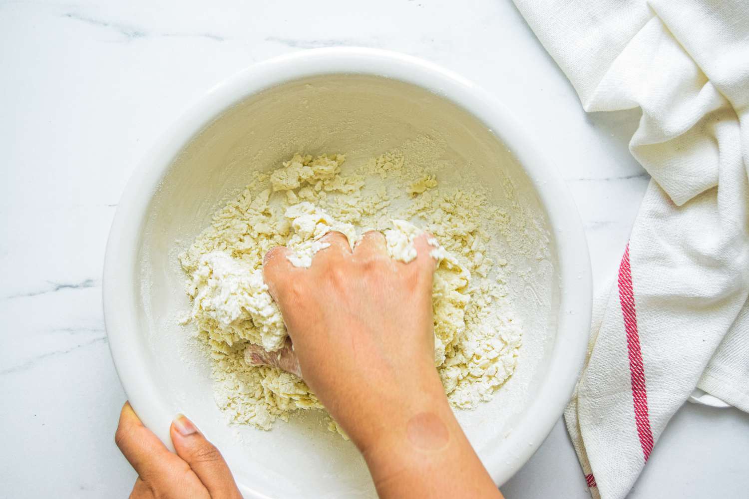Using hands to mix the dough for a scallion pancake recipe.