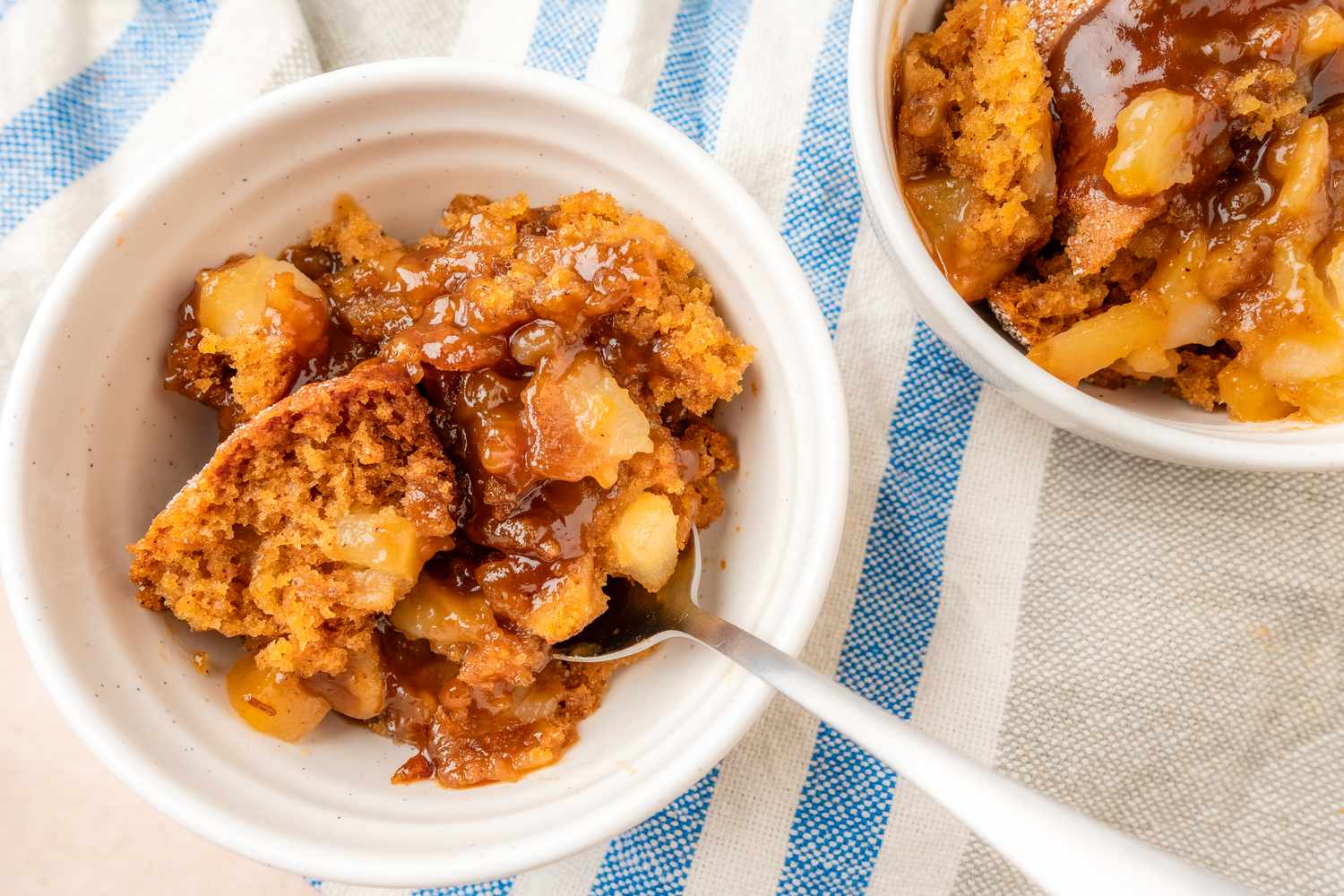 Bowl of pear pudding cake served with a spoon