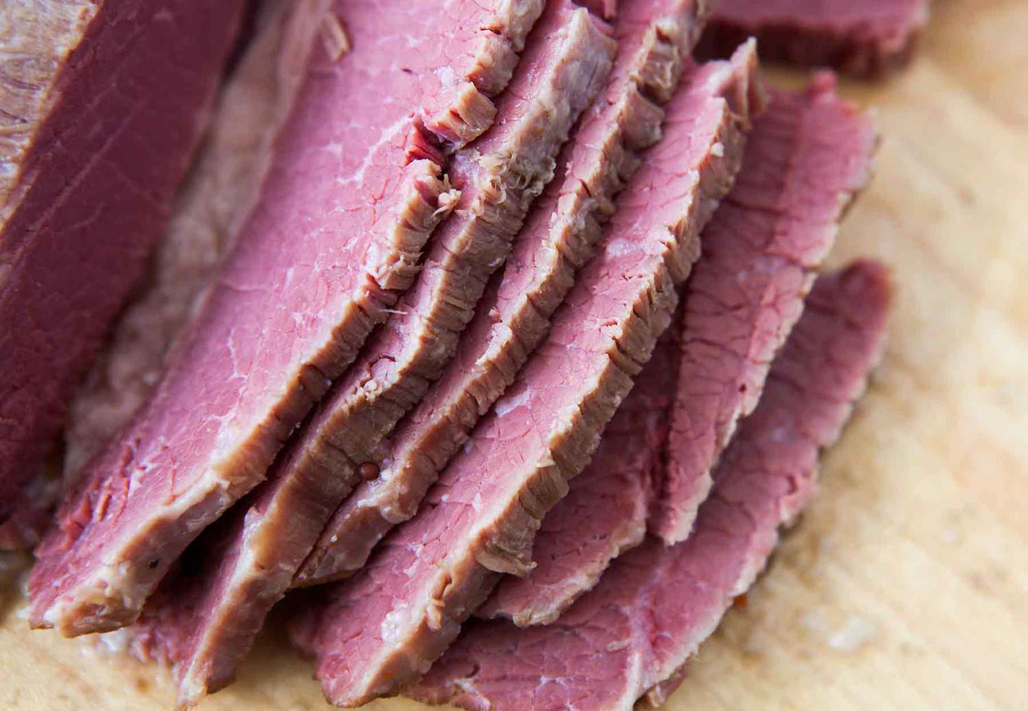 Slices of corned beef on a wooden surface