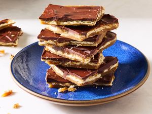 A stack of chocolatecovered cracker candy pieces on a blue plate