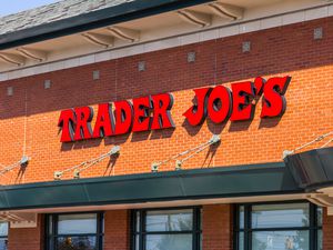 View of the front of a Trader Joe's store and sign on a red brick surface