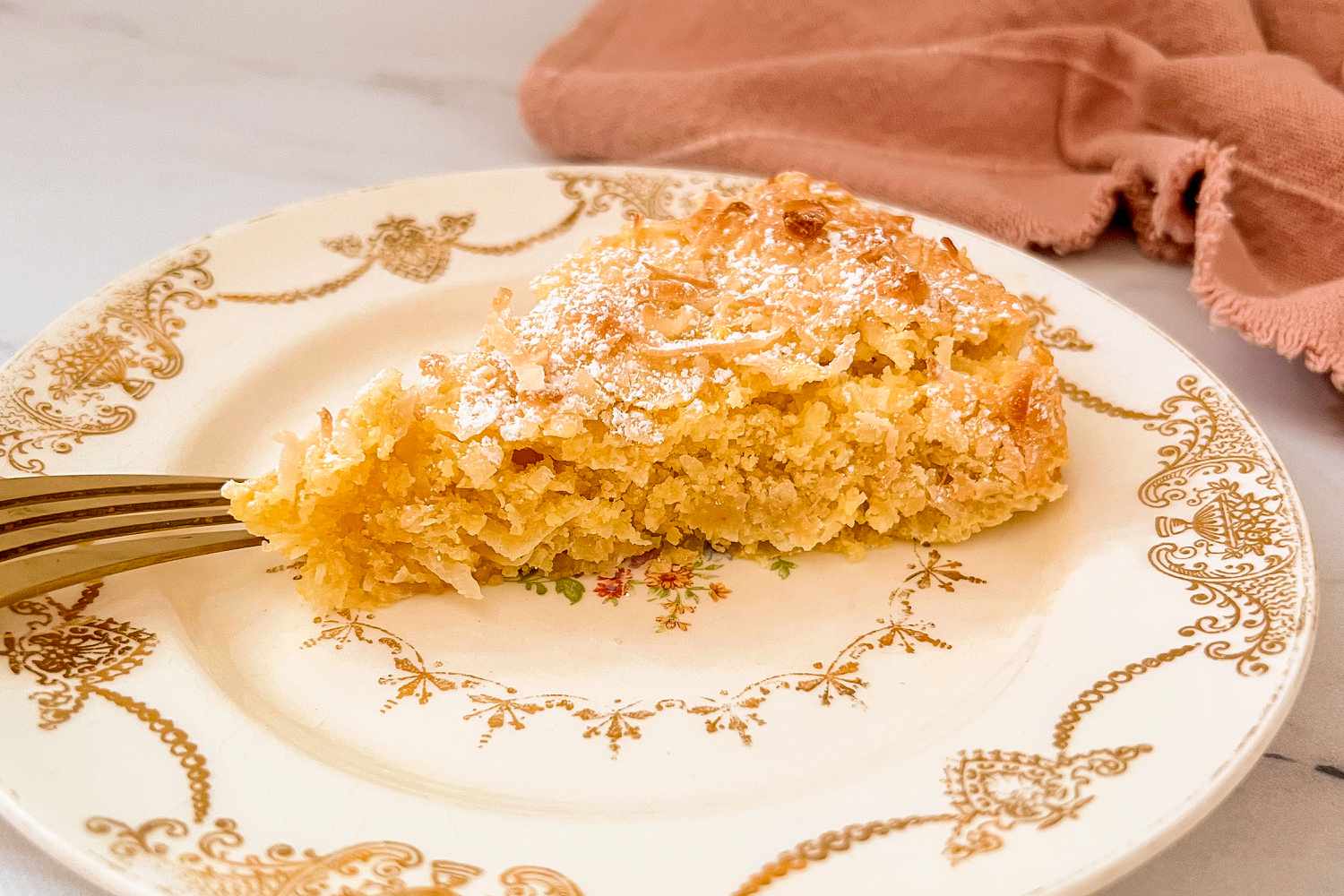 slice of Coconut Macaroon Cake on a dessert plate with a fork