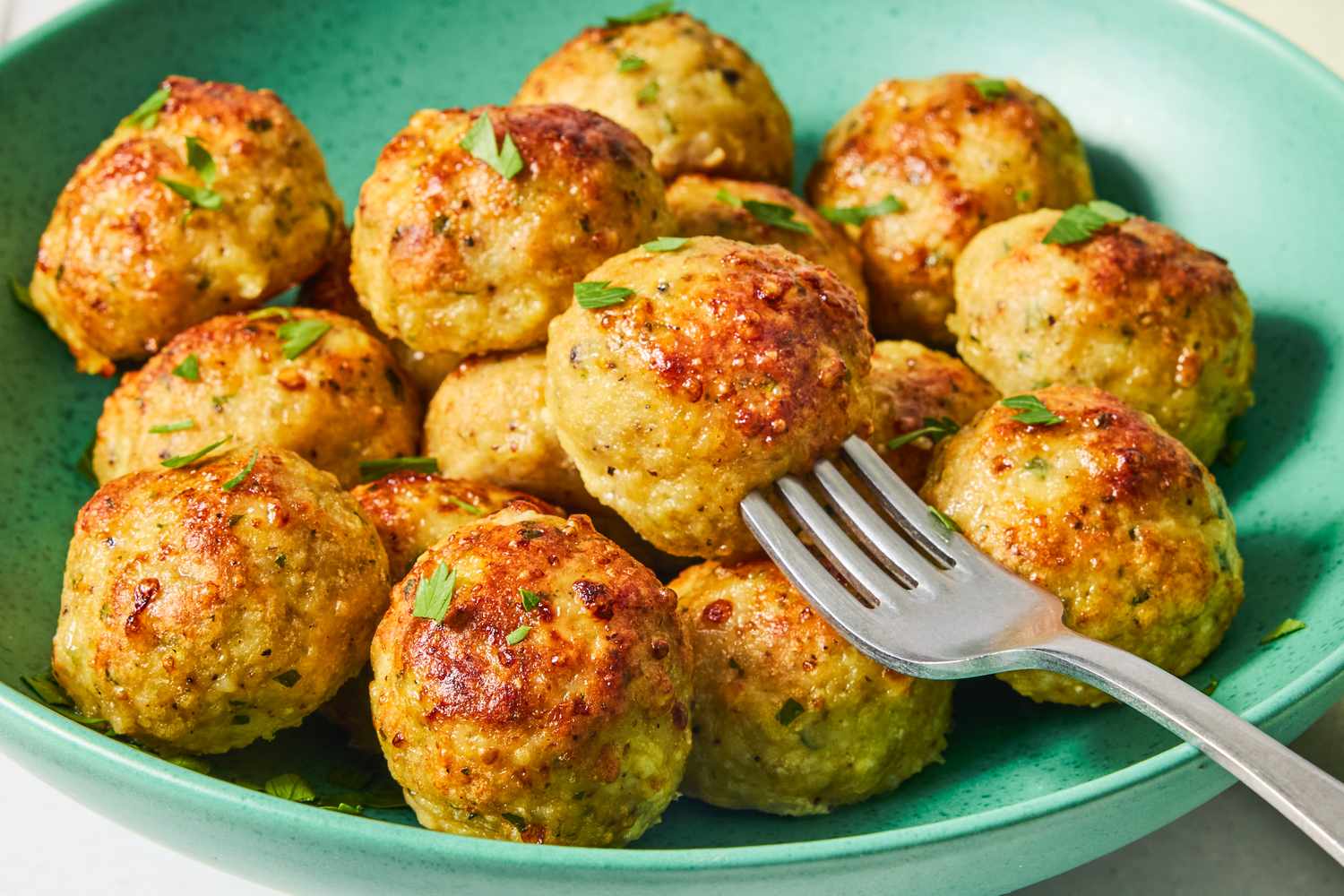 Chicken meatballs served on a plate with a fork