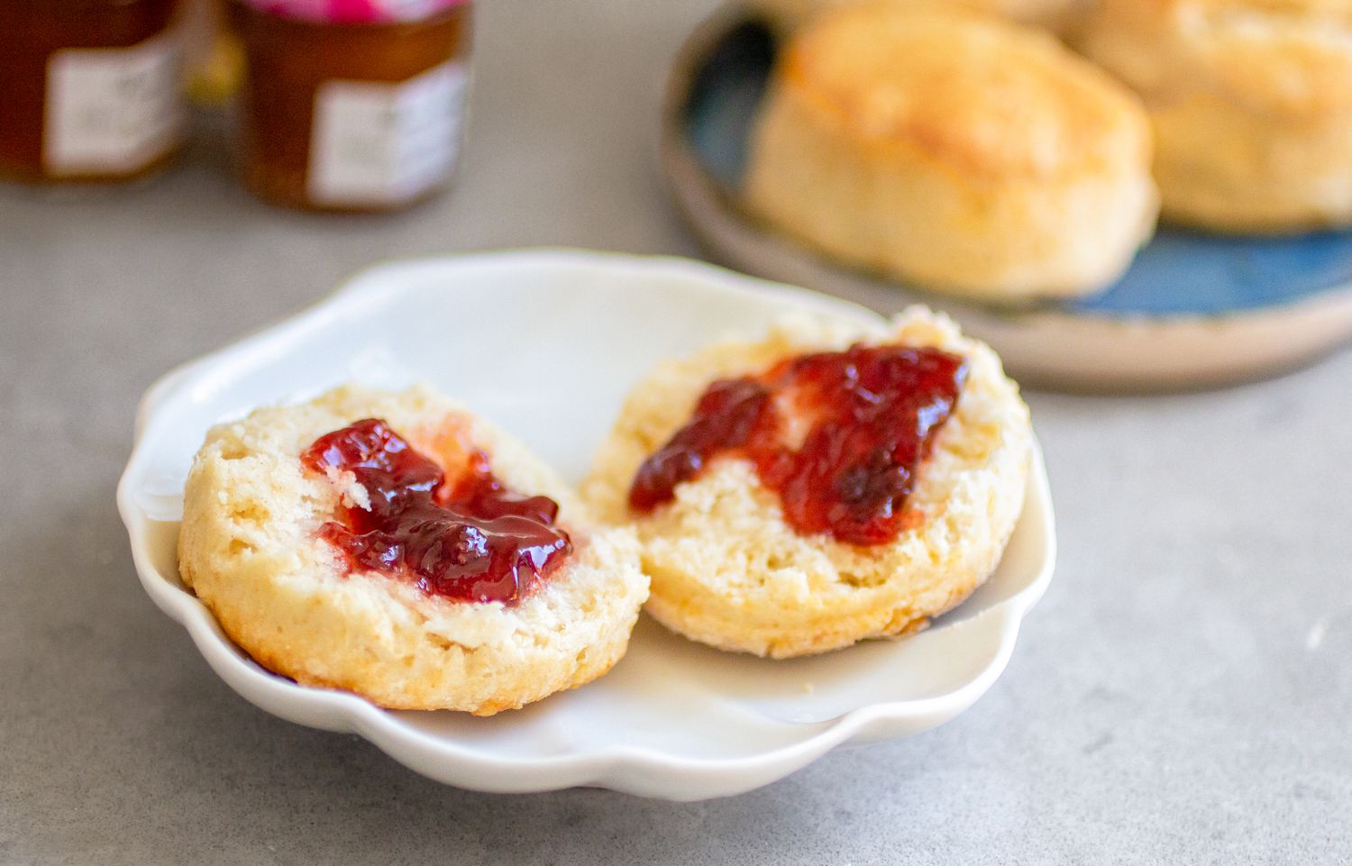 A scone split in half with jam spread on both sides
