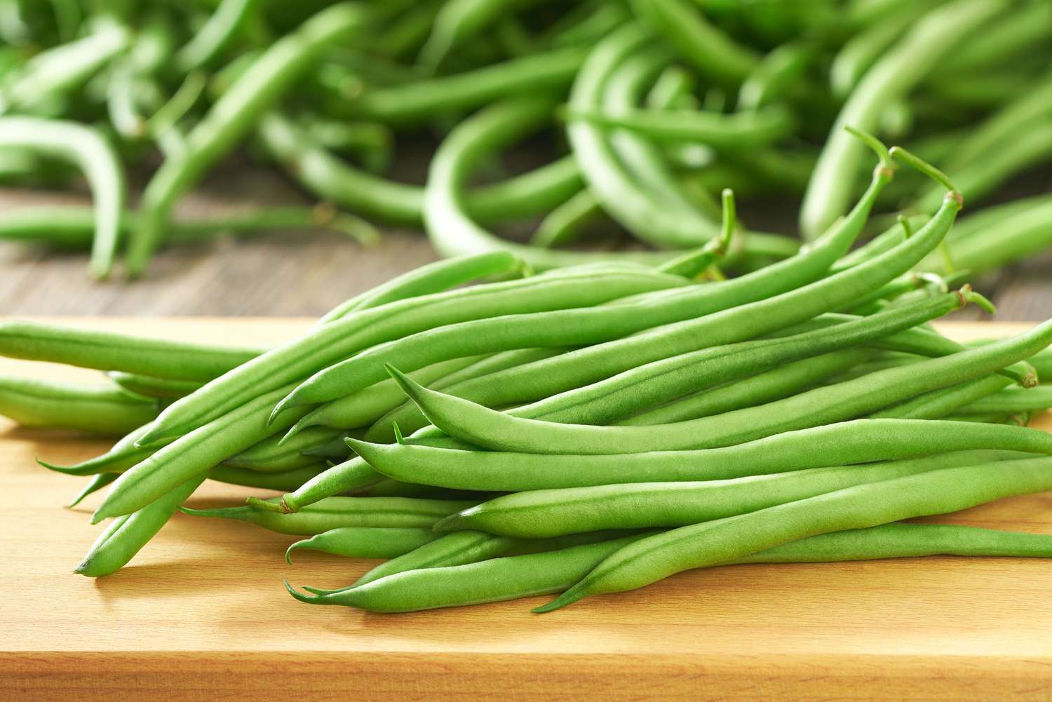 close up of raw green beans on a cutting board