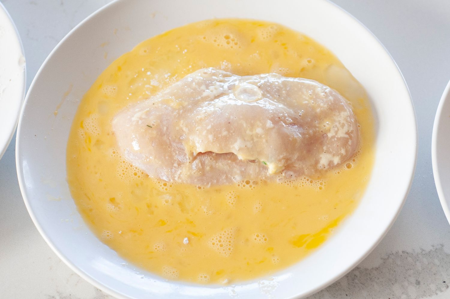 Dip chicken in egg mixture.