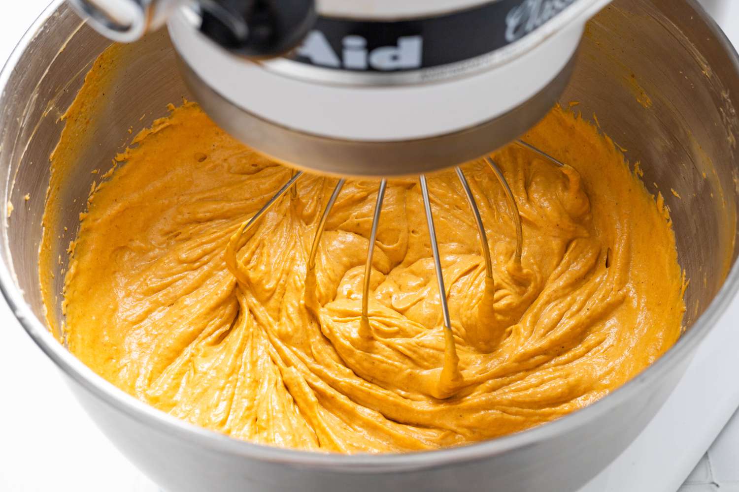 Pumpkin puree filling mixed together in a stand mixer for Cookie crumb, butter, and sugar blended together in a food processor for no-bake pumpkin cheesecake recipe