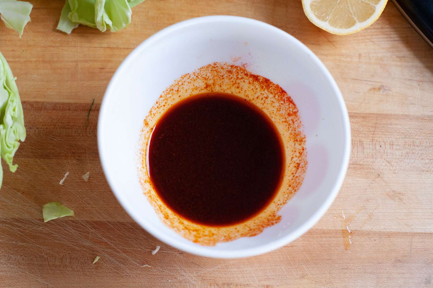 Sauce in a white bowl to make roasted cabbage steaks 