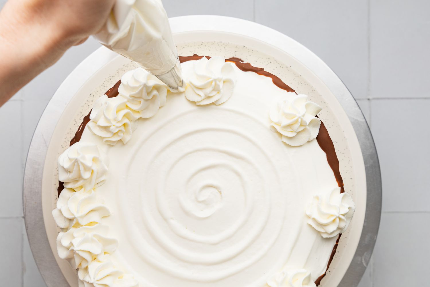 Whipped Cream Rosettes Added to Top of Cake