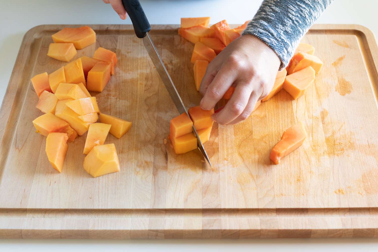 Trimming cubes of papaya