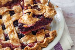 Blackberry Pie in a Pie Dish with a Slice Raised on a Pie Server