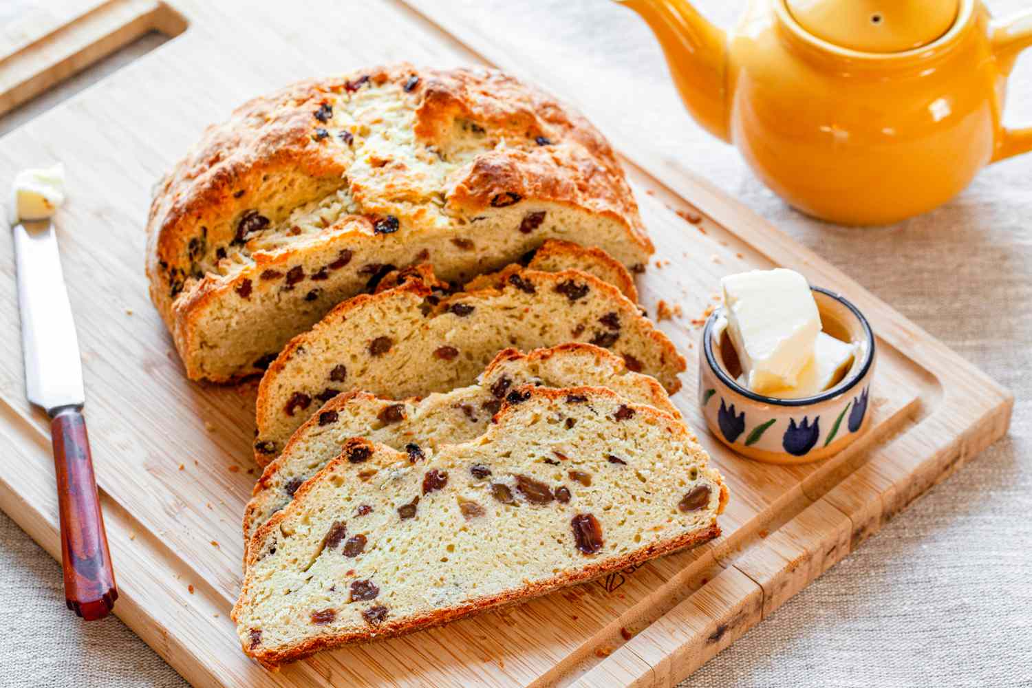 Sliced Irish Soda Bread on a table with a pot of tea