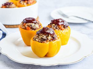 Side view of three bell peppers stuffed with beef and rice.